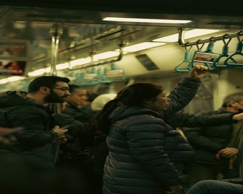 Commuters standing calmly in a train holding the handrails lightly